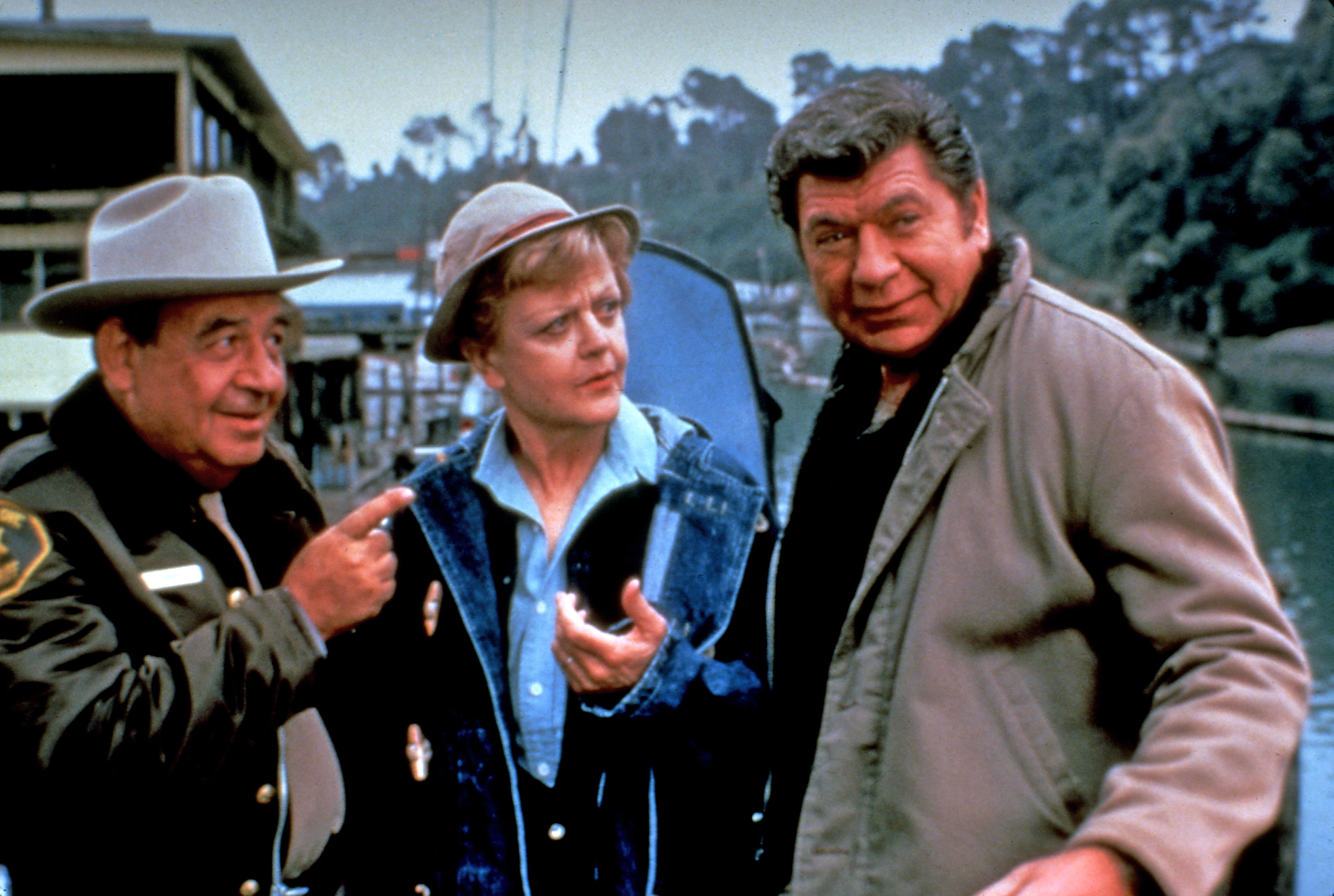 angela lansbury talking to a state trooper and another man outside on a highway in the tv show murder she wrote