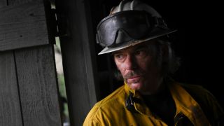 Billy Burke leaning against a building in Fire Country.