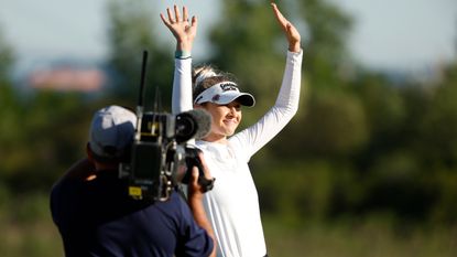 Nelly Korda celebrates winning a tournament with a camera man up close