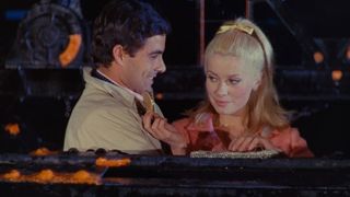 Two French lovers stand on the docks in The Umbrellas of Cherbourg