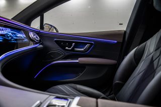 A photo of the EQS interior featuring a black leather seat and interactive dashboard.