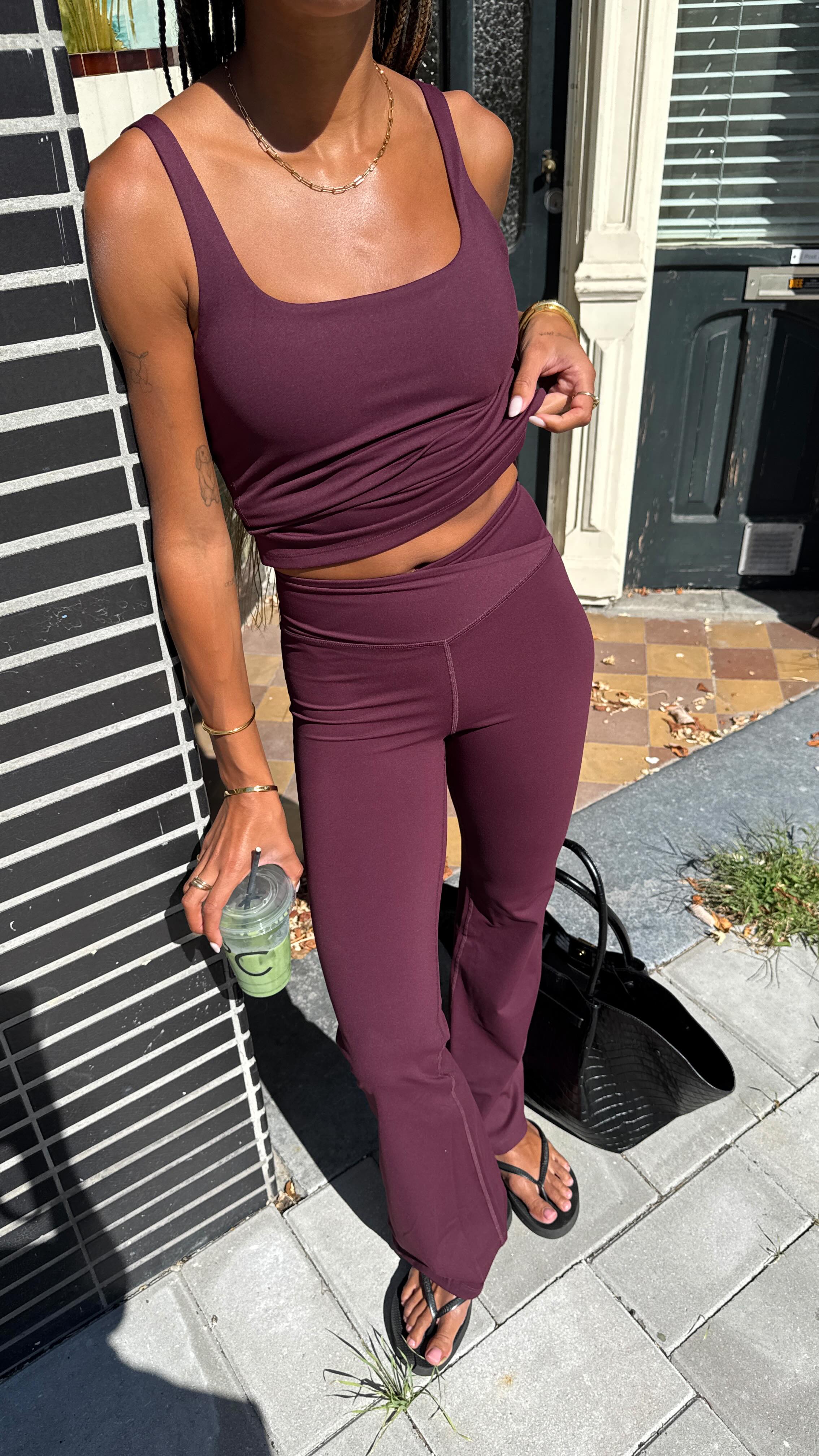 Influencer @amaka.hamelijnck wears burgundy flared leggings with a burgundy tank top.