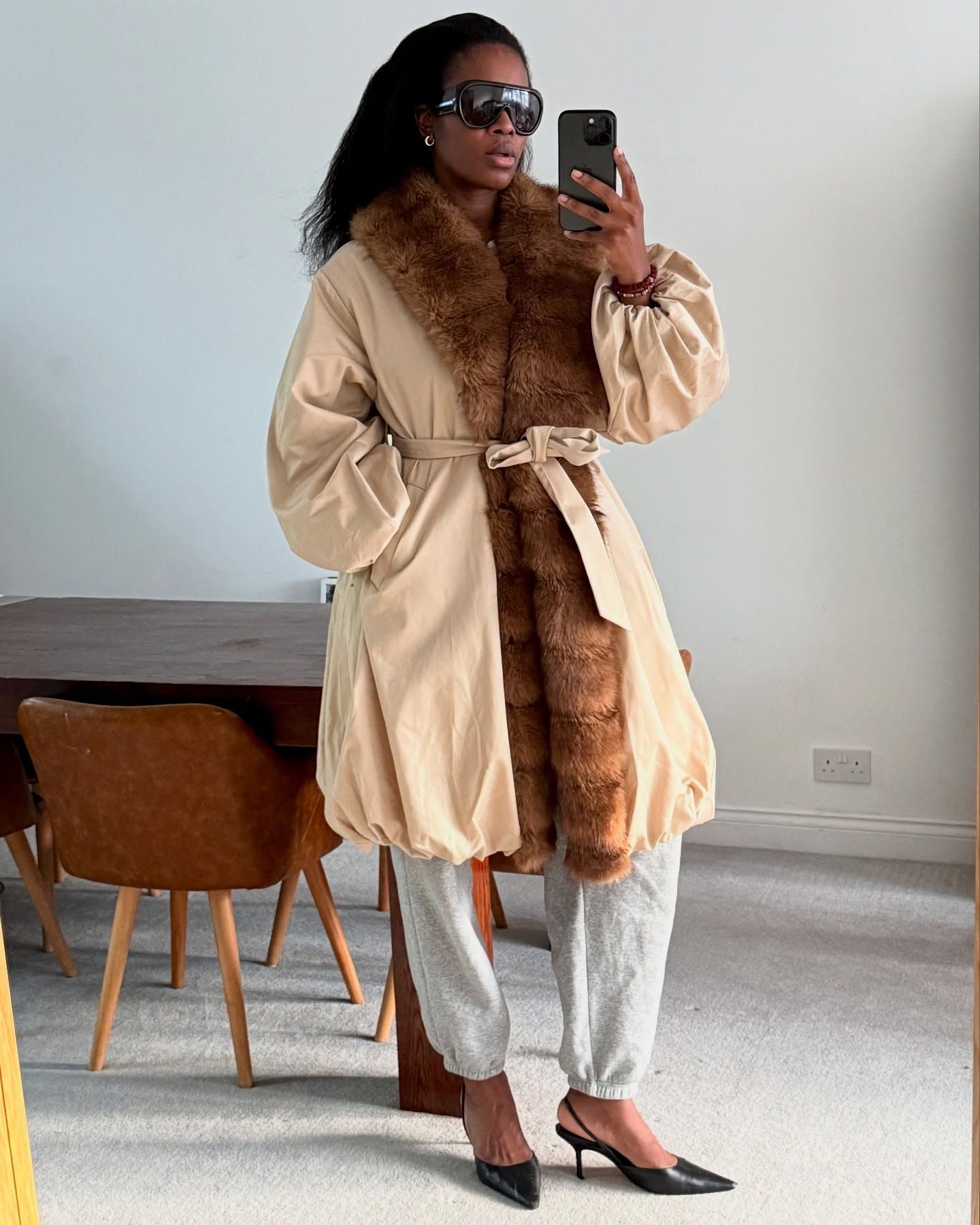 @nlmarilyn wearing a fur-trim coat and gray sweatpants.