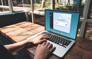 A person works on a laptop that displays Norton VPN software on the screen.