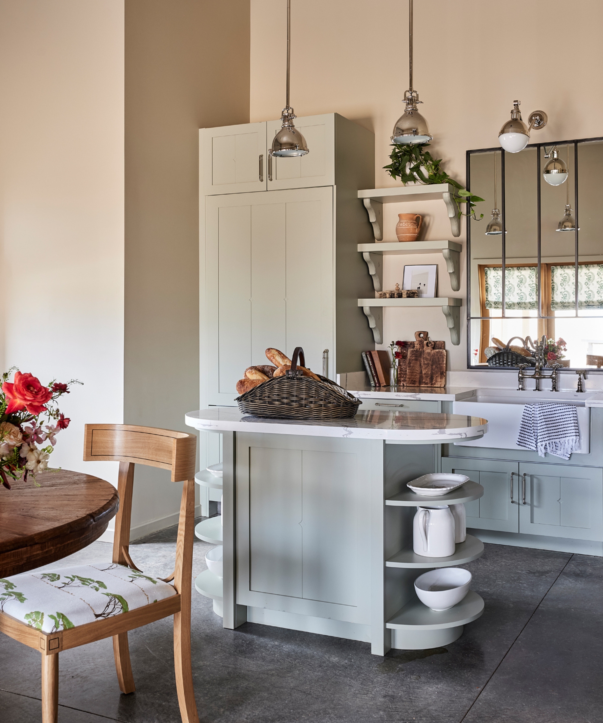 A small kitchen with pale blue cabinets and a curved kitchen island