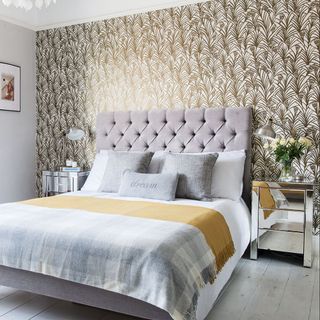 bedroom with metallic wallpaper grey bed with designed cushion and wooden floor