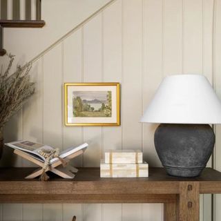 A console table with a book display and a table lamp