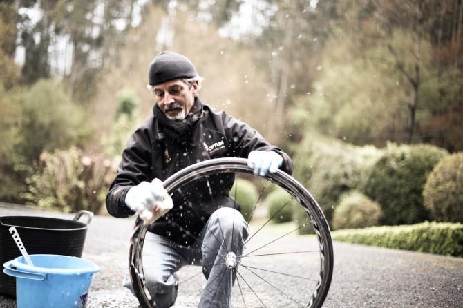 Bob Gregorio speedily cleans a wheel in the team house driveway