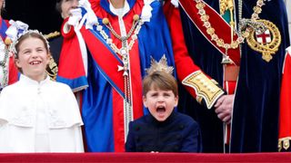 (Princess Charlotte of Wales, Prince Louis of Wales, Catherine, Princess of Wales (wearing the Mantle of the Royal Victorian Order) and Prince William, Prince of Wales (wearing the Mantle of the Order of the Garter) watch an RAF flypast from the balcony of Buckingham Palace following the Coronation of King Charles III & Queen Camilla at Westminster Abbey on May 6, 2023 in London, England