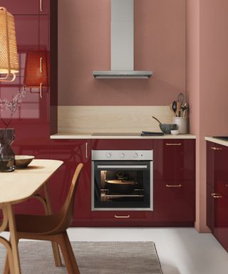 Red and pink kitchen with white floor, rug, table and chairs,