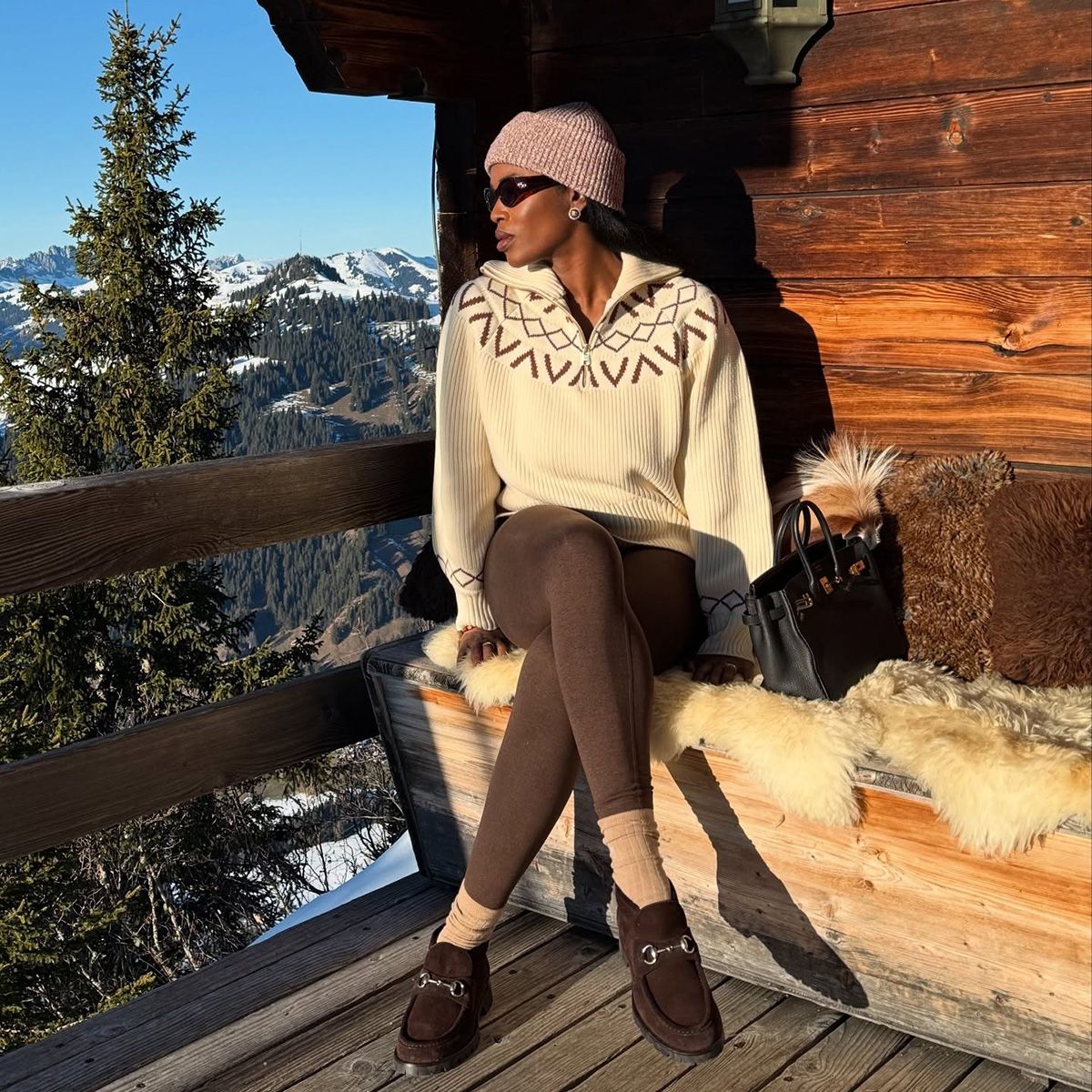 Influencer wearing a half-zip pullover and brown leggings at a ski resort