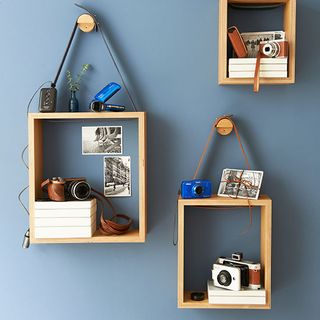 blue wall with shelves and photos with postcards