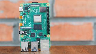 A Raspberry Pi 4 board in front of a red brick wall