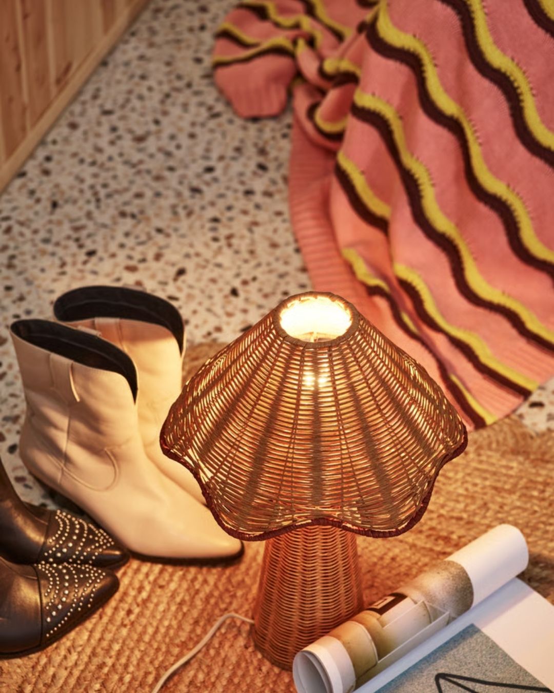 A series of sculptural rattan decorative items, including place mats, cake stands, laundry baskets, lights, napkin rings, and storage units.