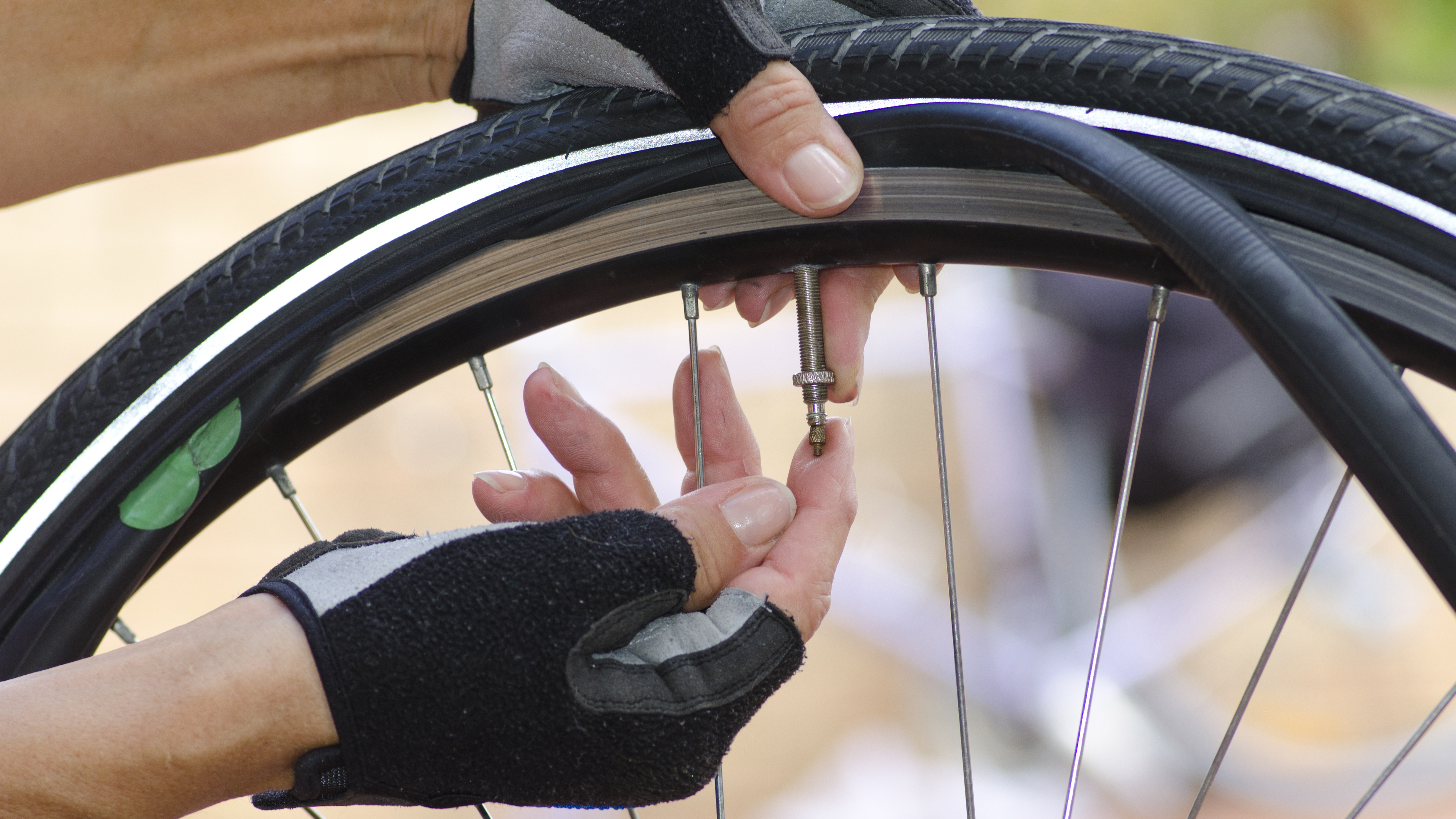 a person's hands adjusting the inner tube on a bike wheel