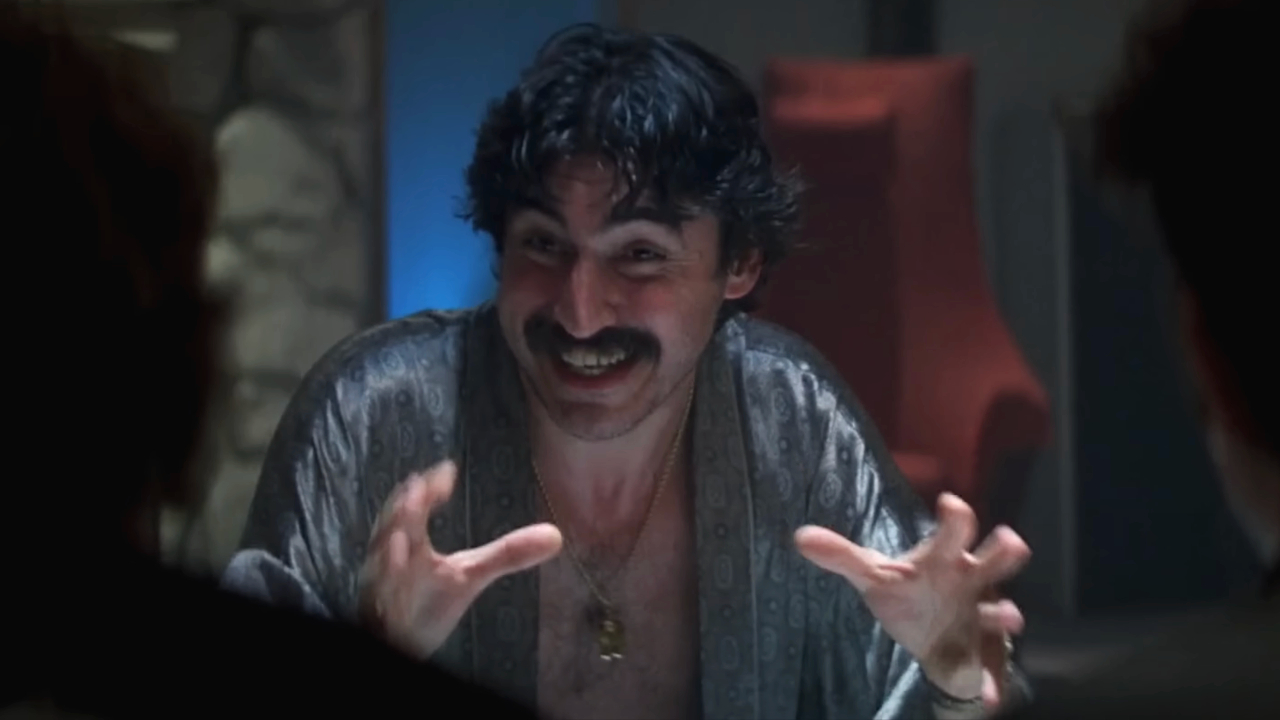 A crazed Alfred Molina raises his hands in conversation in Boogie Nights.