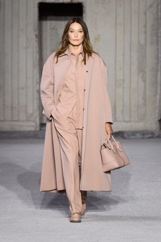 Carla Bruni walks in Tod’s S/S 2023 with beige outfit, bag and shoes