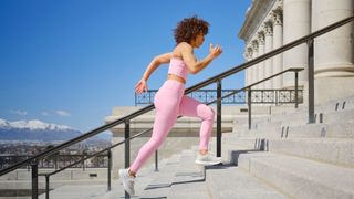 Woman wearing activewear running up steps