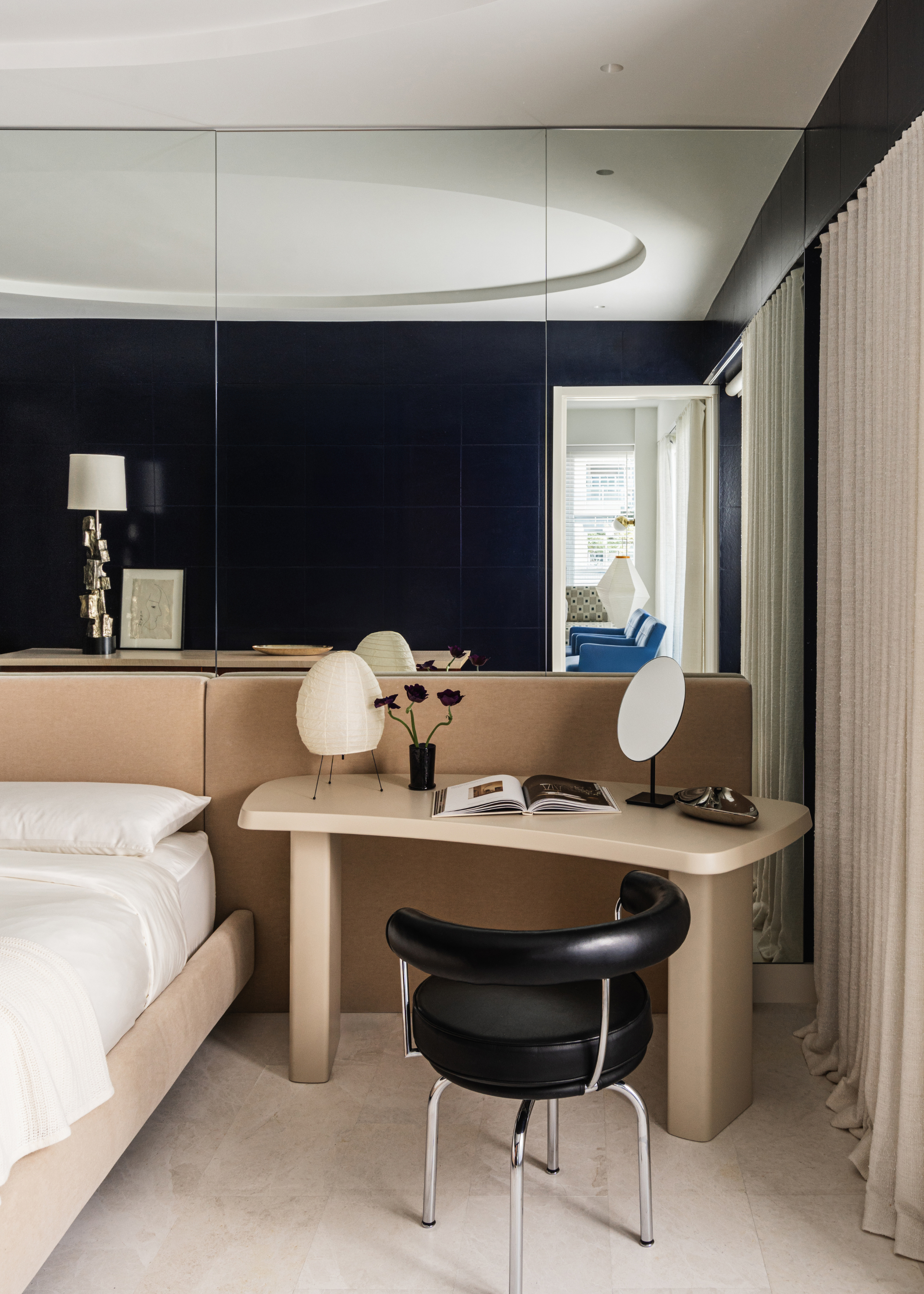 art deco modern bedroom with desk bedside table and mirrored walls