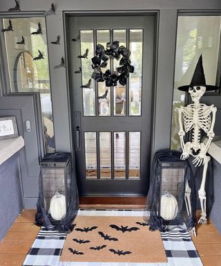 Halloween outdoor door decor with striped doormat and skeleto
