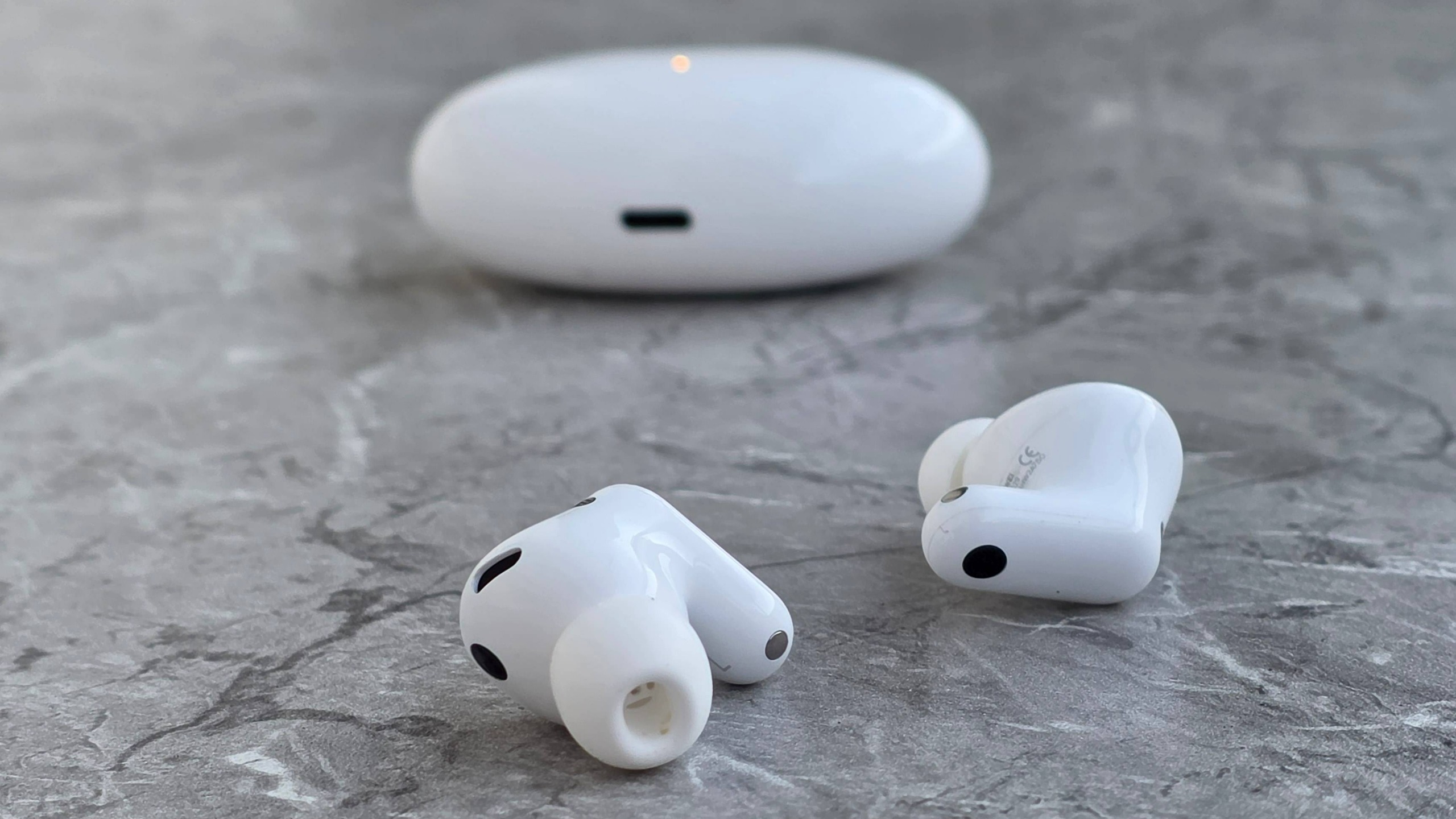 The Huawei FreeBuds Neo buds and case on a marbled surface.