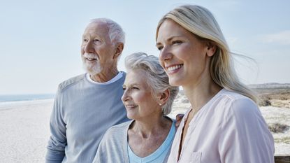 An older couple and their adult daughter at the beach.