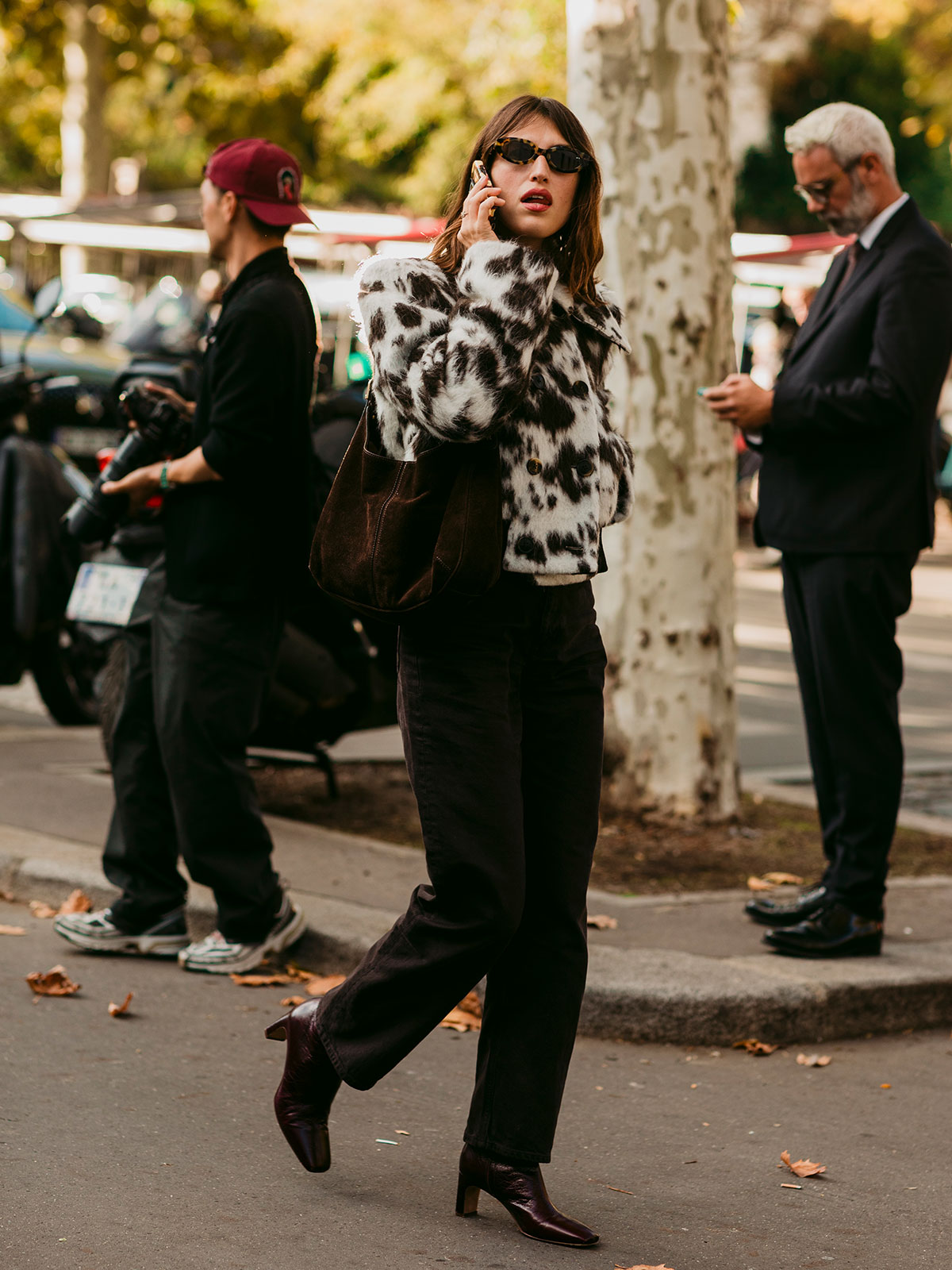 Woman wearing a cow-print coat.