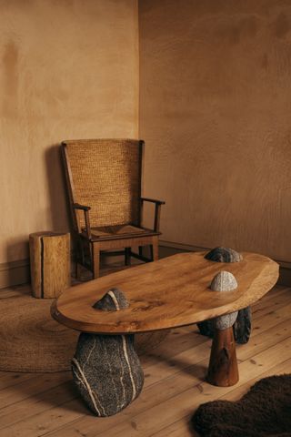 a wood coffee table design that balances on natural rocks