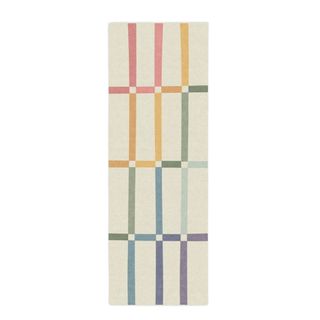 A colorful runner rug with a beige background and a rainbow cross pattern
