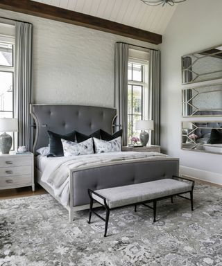 All gray bedroom with trio of gray angular mirrors on the wall
