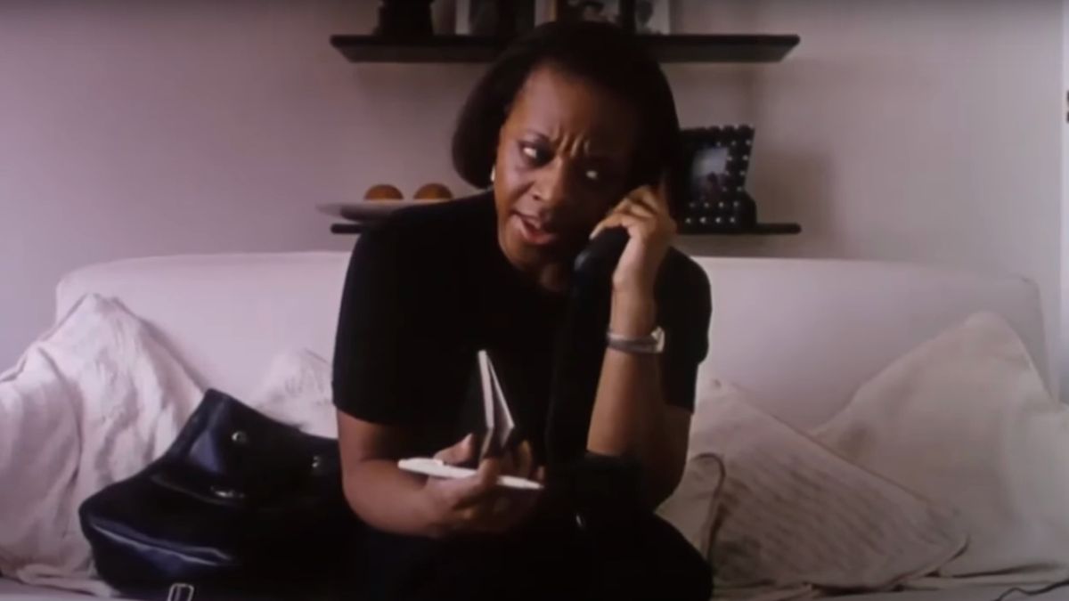 Marianne Jean-Baptiste sits on a white couch in the middle of a phone call in Secrets and Lies.