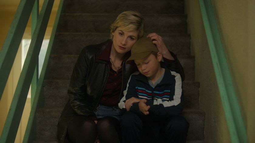 Susan sits on the stairs with her son Connor, holding his head, in Toxic Town