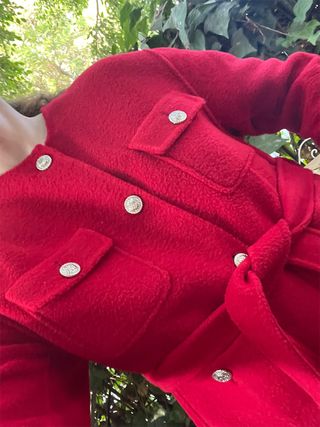 Erin Fitzpatrick wearing a red belted cardigan.