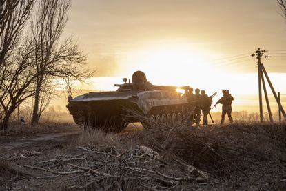 Ukrainian servicemen approach a battlefield outside Kyiv