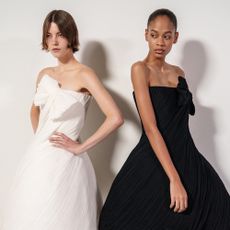 Models backstage at fashion week wearing minimal makeup, nude lipstick and off-shoulder gowns