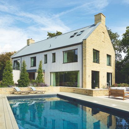 exterior of new build timber frame and stone house with swimming pool