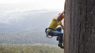 a guide to climbing grades: climber on rock wall