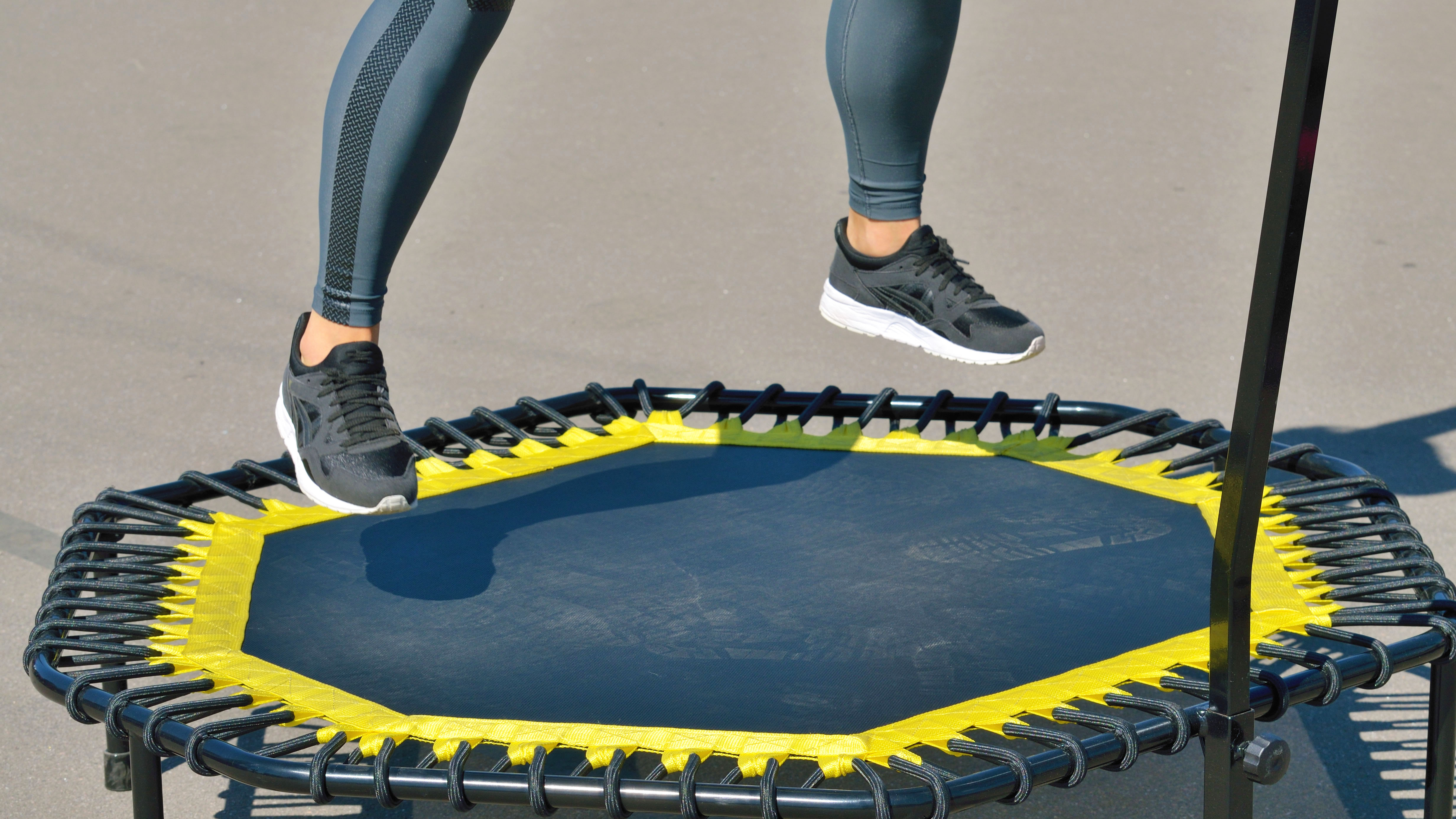 a photo of a woman jumping on a mini trampoline