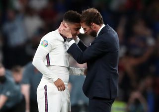 England manager Gareth Southgate consoles Jadon Sancho following defeat in the penalty shoot-out that decided Euro 2020