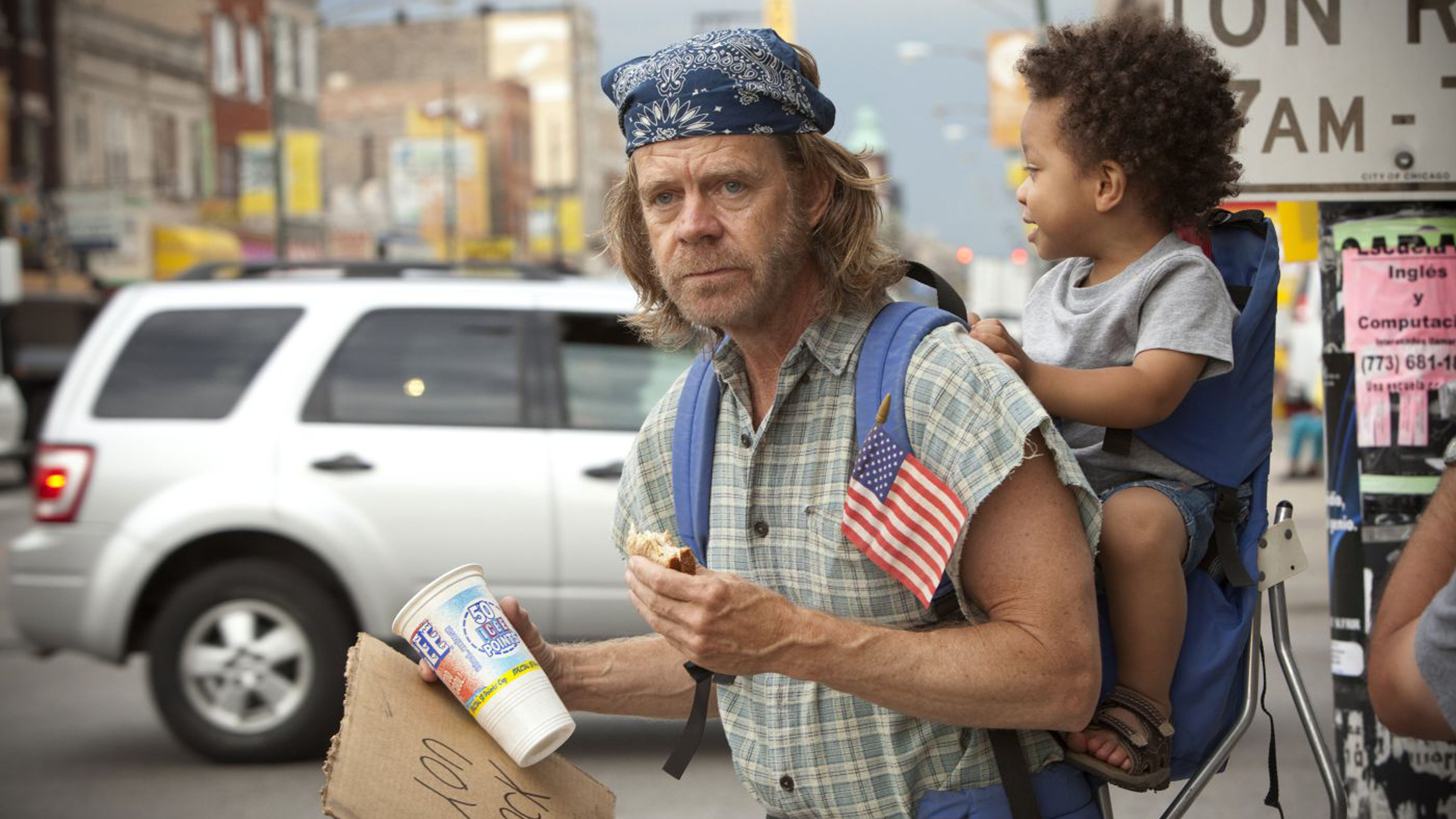 William H. Macy as Frank carrying a baby on his back in Shameless