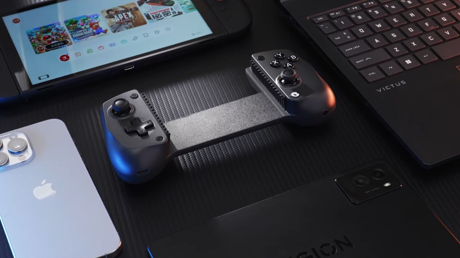 The GameSir X5s laying on a desk next to various gaming devices