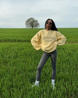 @chrissyford wearing grey leggings, slogan sweatshirt and trainers