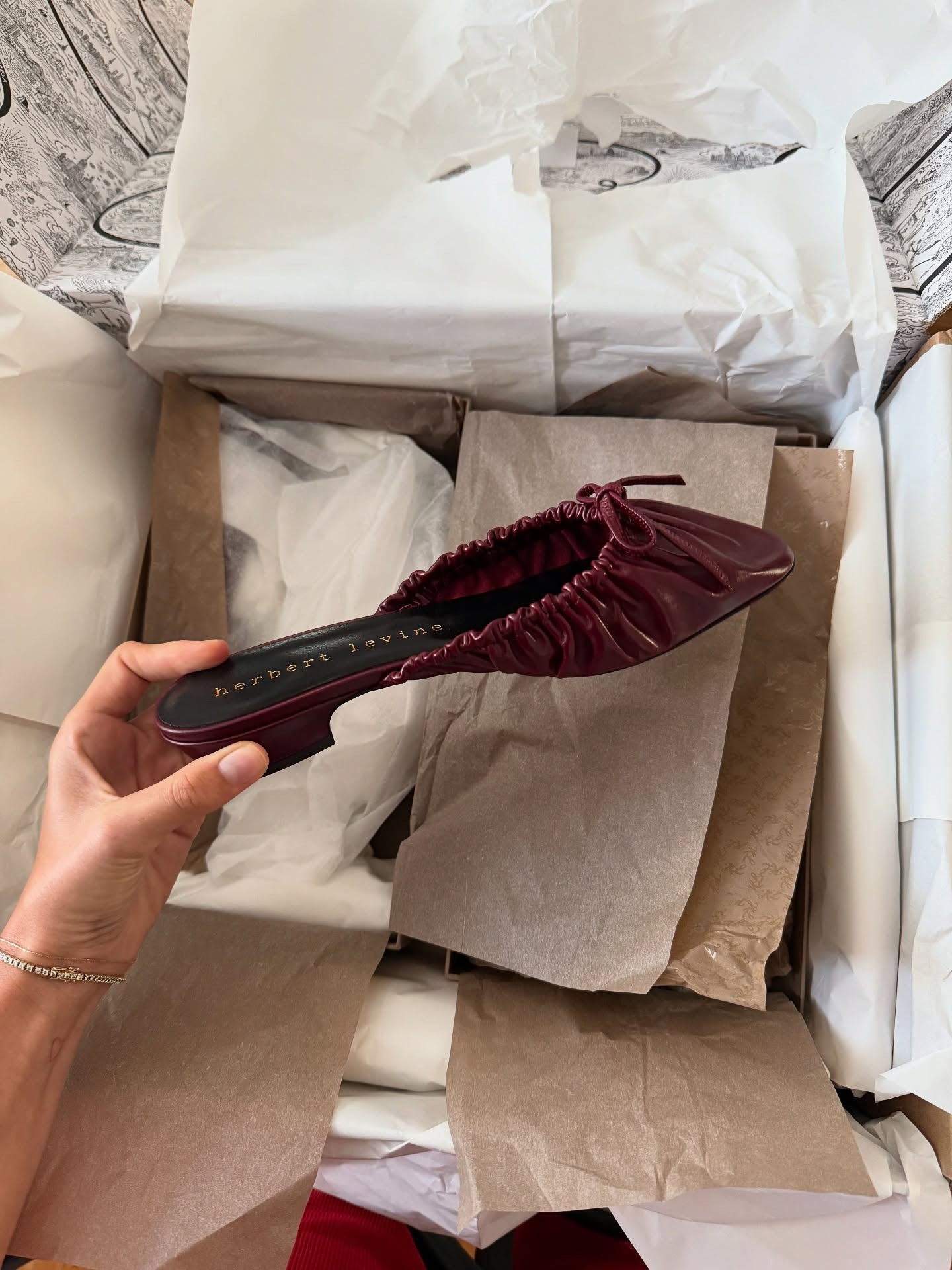 lizzyhadfield wears a hybrid summer shoe trend. She shoes a gathered front, backless mule in burgundy.