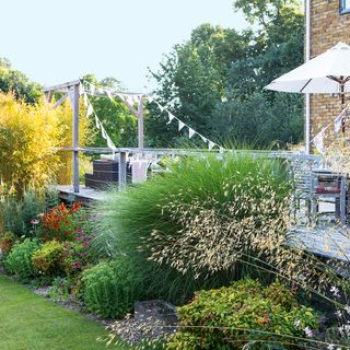 garden with outdoor dining space and brick wall house