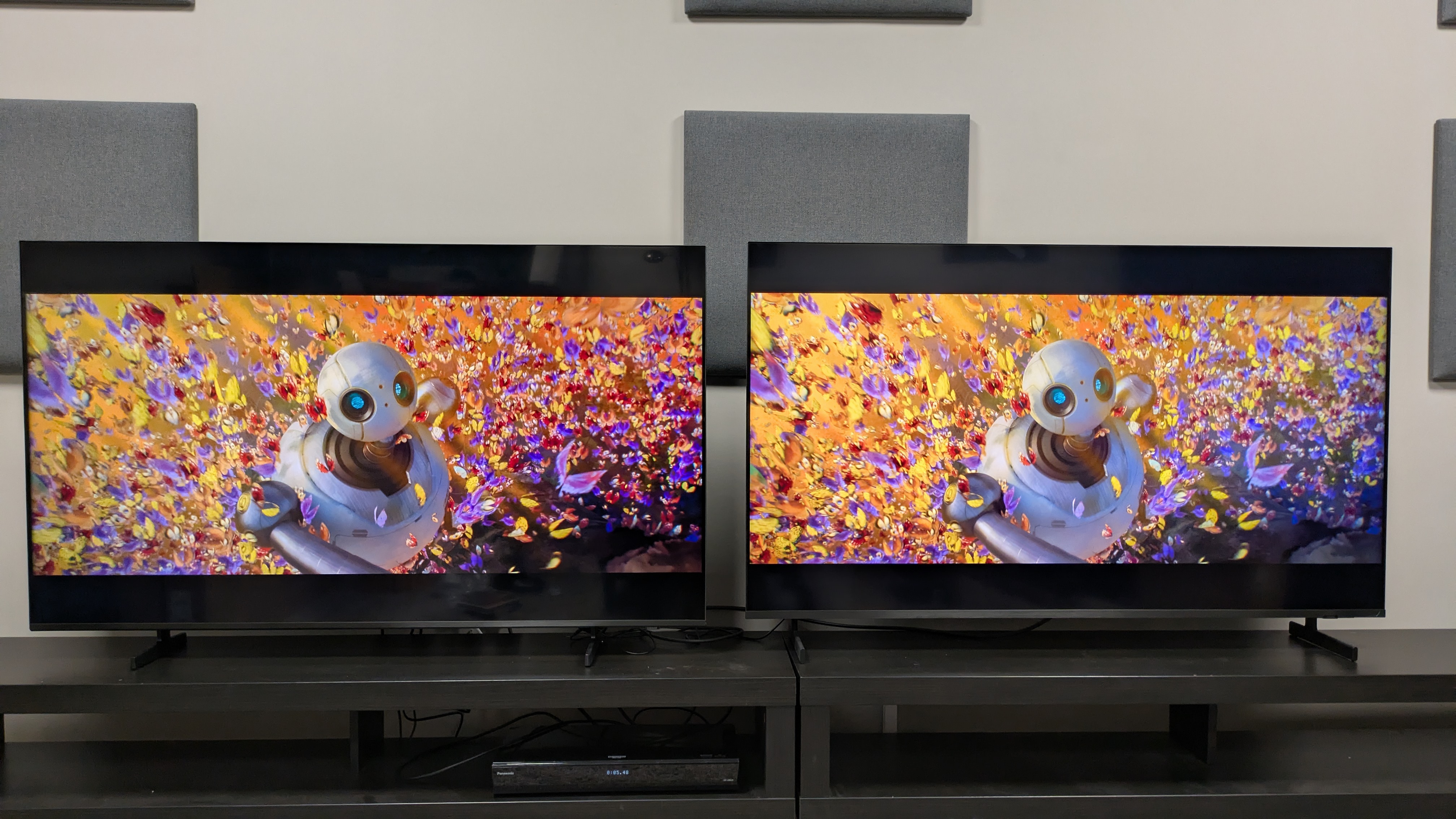 Samsung M80H (left) vs Samsung QN80H (right) showing Roz in butterfly swarm. Both TVs have good colors, but the QN80H's are brighter and bolder