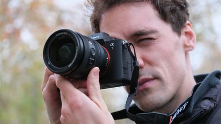 Sony A7 V camera held up to a person's face