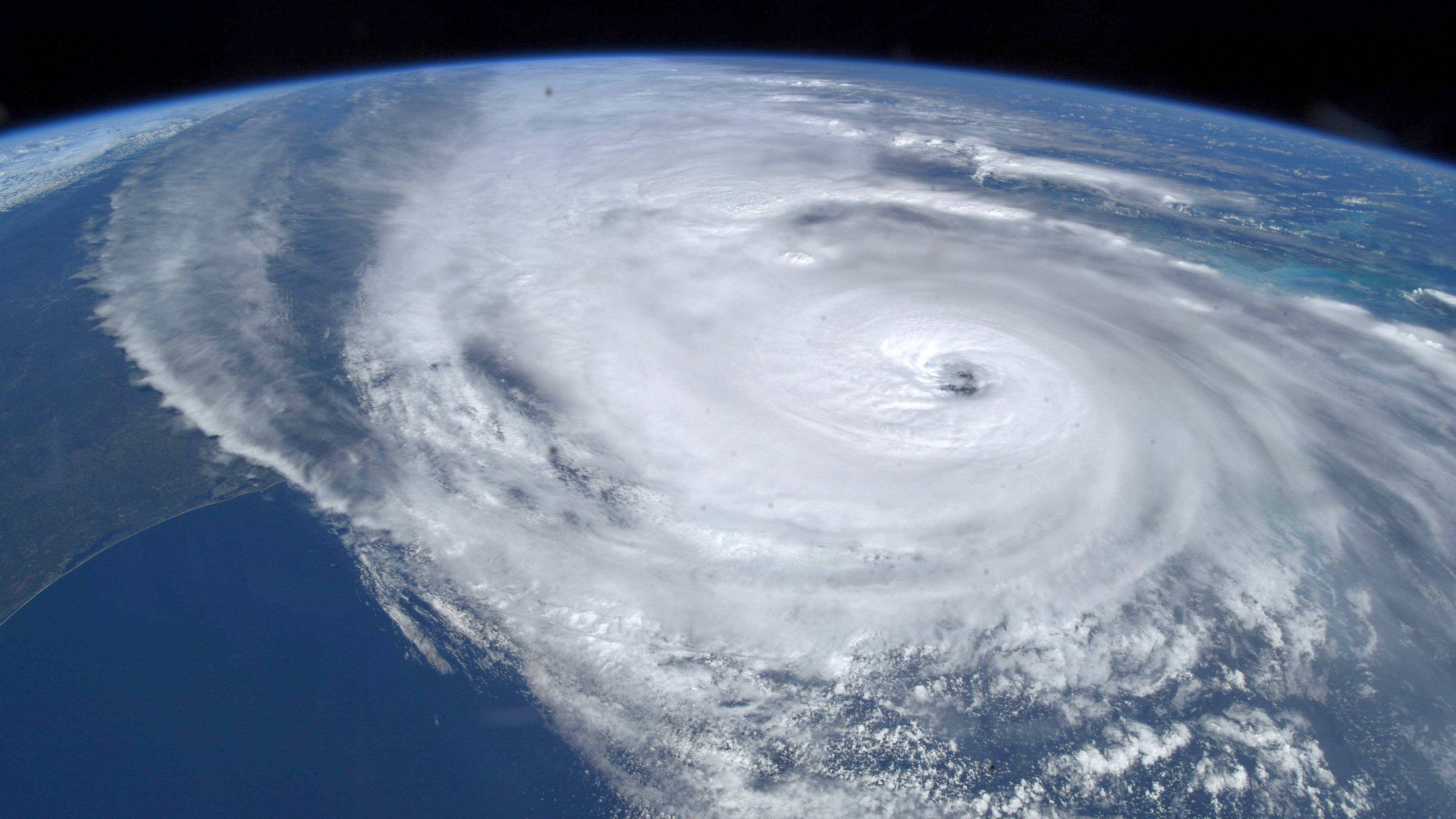 hurricane visible from space over land and water. the curve of the earth is visible