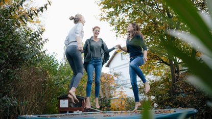 women trampolining in garden