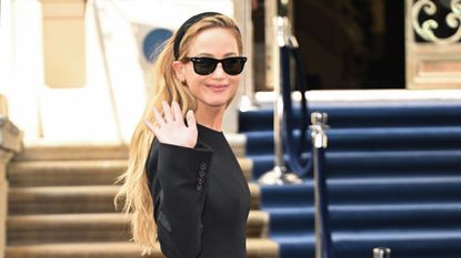 Jennifer Lawrence in a black mini dress, sunglasses, and headband