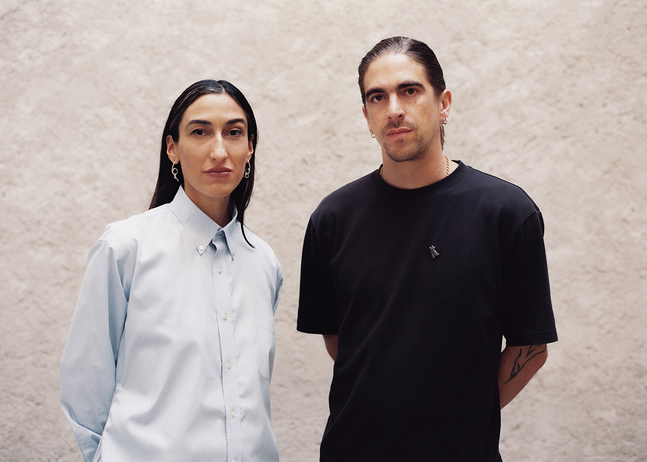 portrait of LANZA founders isabel abascal and Alessandro Arienzo against white wall wearing lack and white